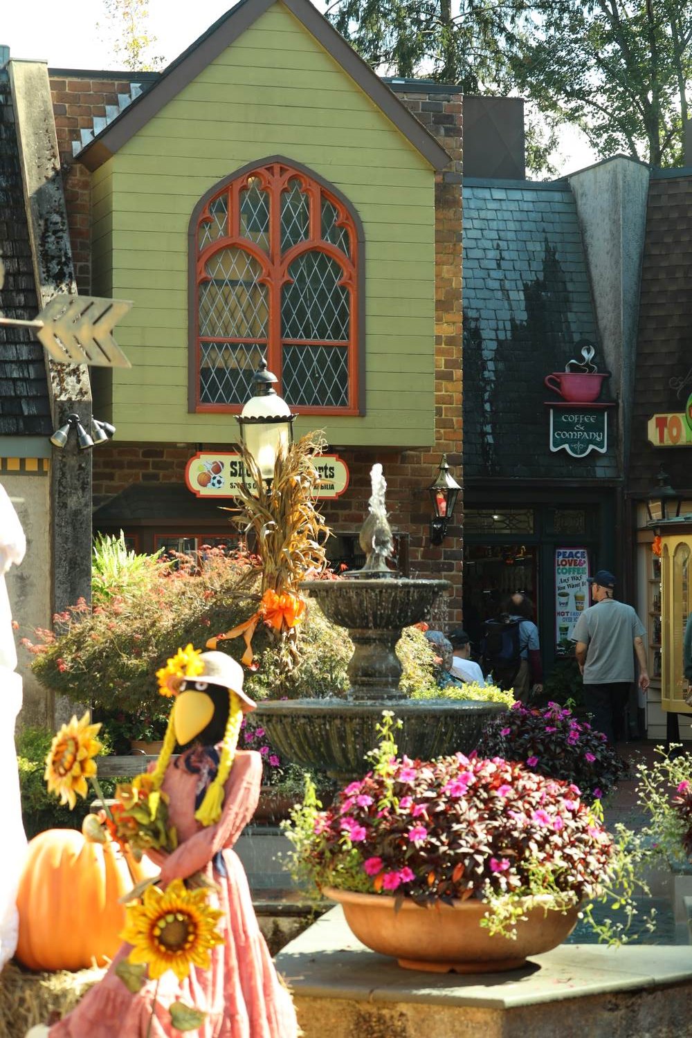 Crow scarecrow with sunflowers and a pumpkin by a fountain in downtown Gatlinburg